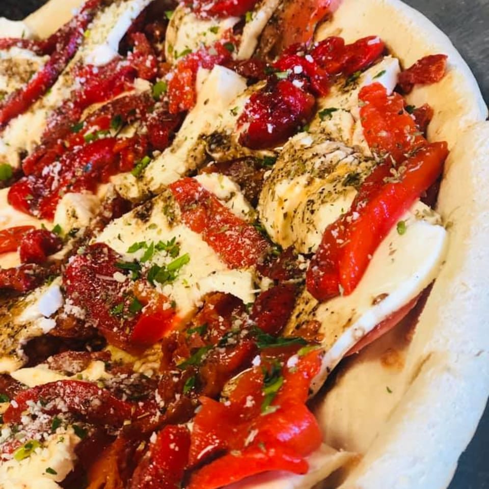 Pennachio's pizza with red peppers, mozzarella, and herbs on a thick crust.